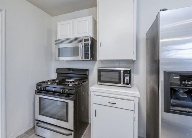 kitchen featuring appliances with stainless steel finishes and white cabinets