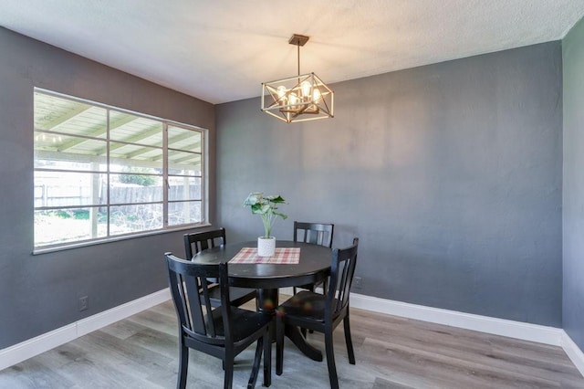 dining space with a notable chandelier and hardwood / wood-style floors