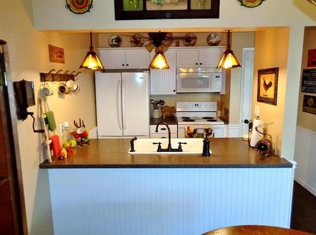 kitchen with hanging light fixtures, white cabinets, white appliances, and kitchen peninsula