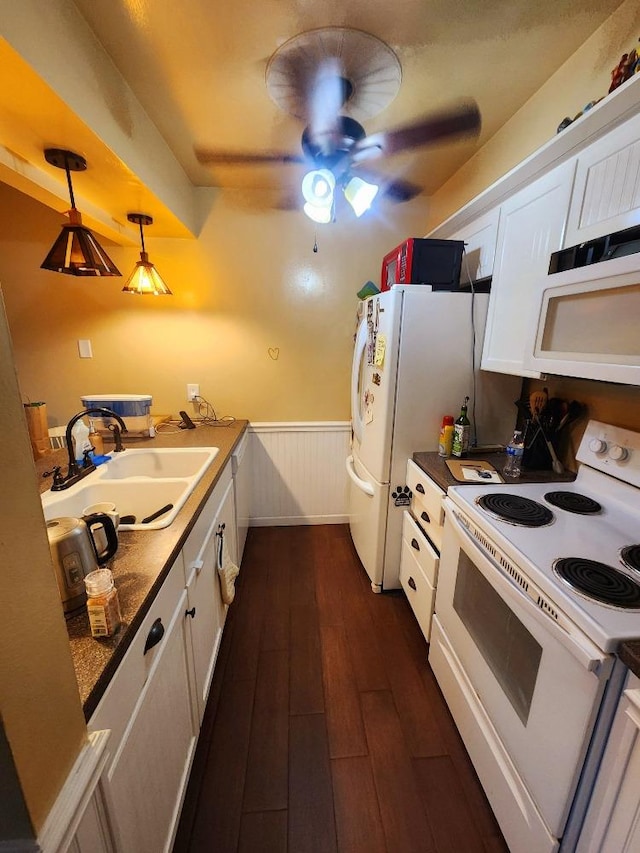 kitchen featuring sink, white cabinetry, dark hardwood / wood-style flooring, pendant lighting, and white appliances