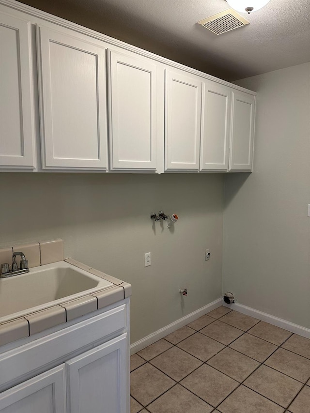 laundry room featuring hookup for a washing machine, cabinets, hookup for an electric dryer, light tile patterned flooring, and hookup for a gas dryer