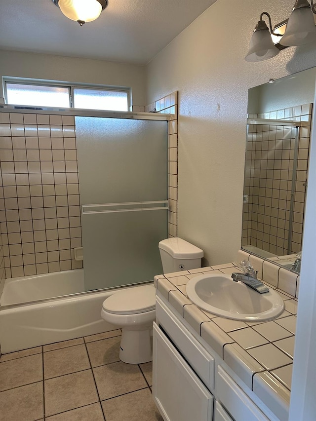 full bathroom with toilet, vanity, tile patterned floors, and combined bath / shower with glass door