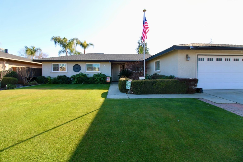 single story home with a front yard and a garage