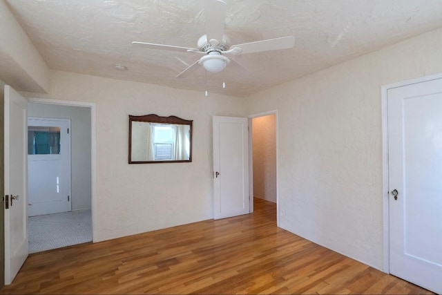 spare room with hardwood / wood-style floors, a textured ceiling, and ceiling fan