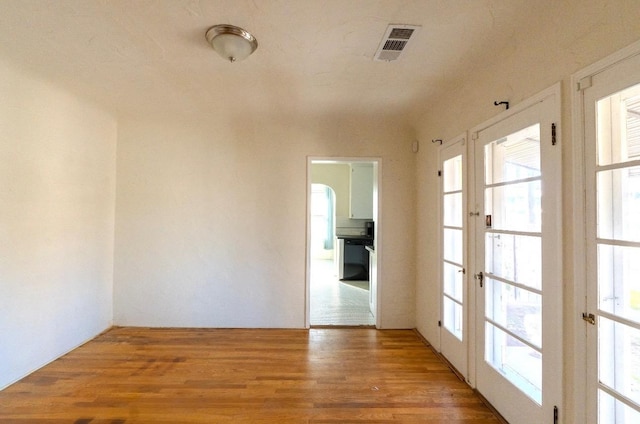 empty room featuring french doors and hardwood / wood-style floors