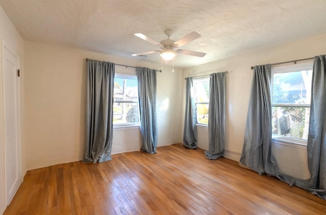 unfurnished room featuring ceiling fan, a textured ceiling, and wood-type flooring