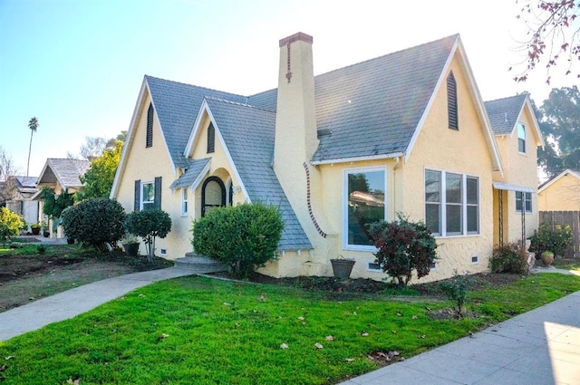 tudor-style house with a front lawn