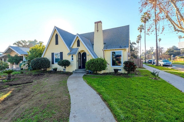 english style home featuring a front lawn