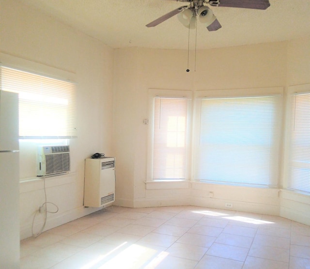 tiled spare room featuring cooling unit, ceiling fan, and heating unit