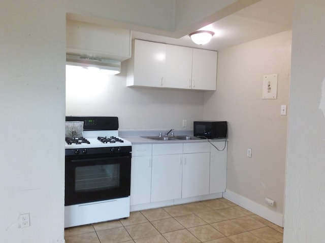 kitchen featuring range with gas cooktop, light tile patterned floors, white cabinets, and sink