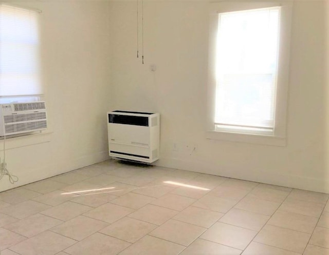 spare room with light tile patterned flooring, cooling unit, and heating unit