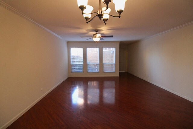 spare room featuring ceiling fan with notable chandelier, dark hardwood / wood-style flooring, and ornamental molding