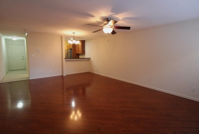 unfurnished living room with ceiling fan with notable chandelier, dark wood-type flooring, and crown molding