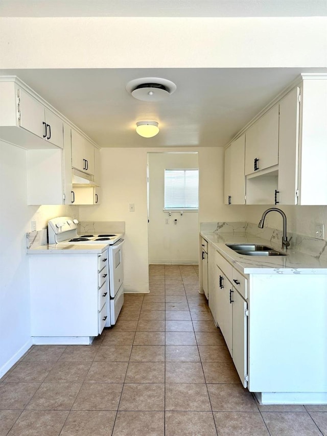 kitchen with sink, electric range, light tile patterned floors, and white cabinetry