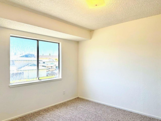 carpeted spare room featuring a textured ceiling