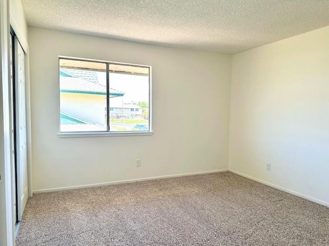 spare room with carpet floors and a textured ceiling