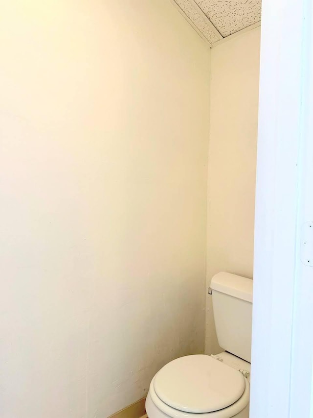 bathroom with a paneled ceiling and toilet