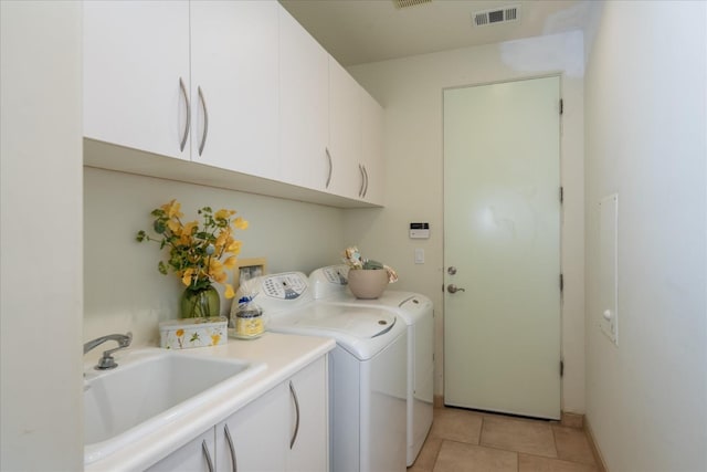 washroom with sink, cabinets, independent washer and dryer, and light tile patterned floors