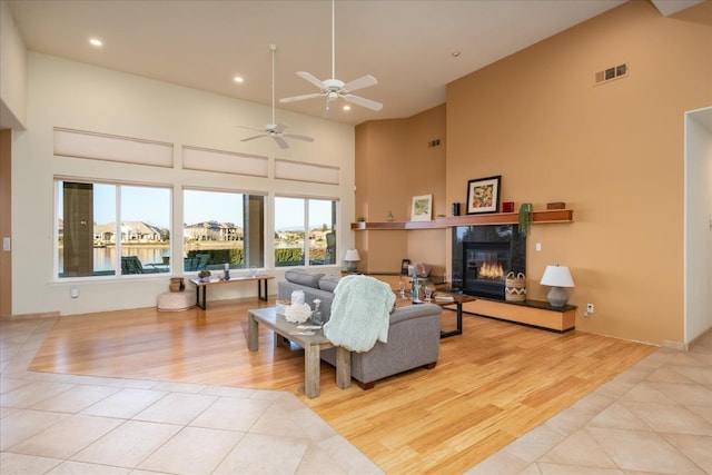 tiled living room featuring a tile fireplace and a high ceiling