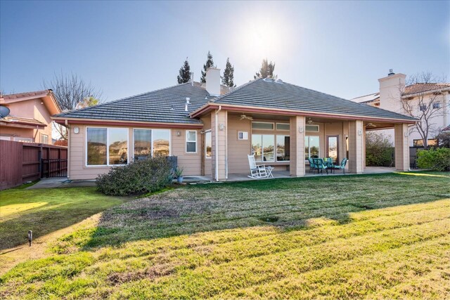 rear view of house featuring a lawn, a patio area, and ceiling fan