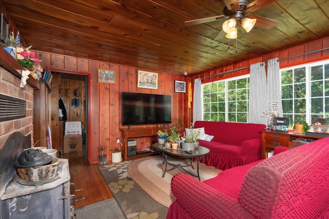 living room featuring wood-type flooring, wooden walls, ceiling fan, and wooden ceiling