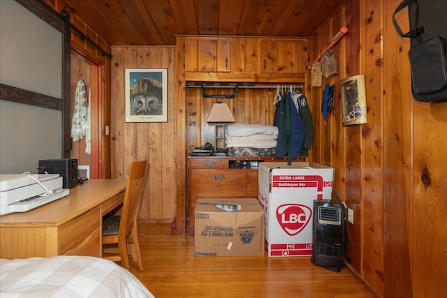 interior space with wood ceiling, hardwood / wood-style floors, wooden walls, and a barn door