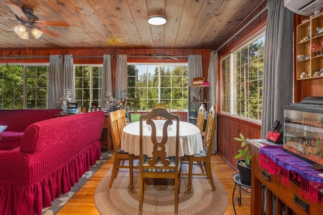 sunroom / solarium with a healthy amount of sunlight, a wall unit AC, ceiling fan, and wood ceiling