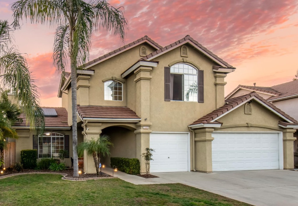 view of front of house featuring solar panels, a yard, and a garage