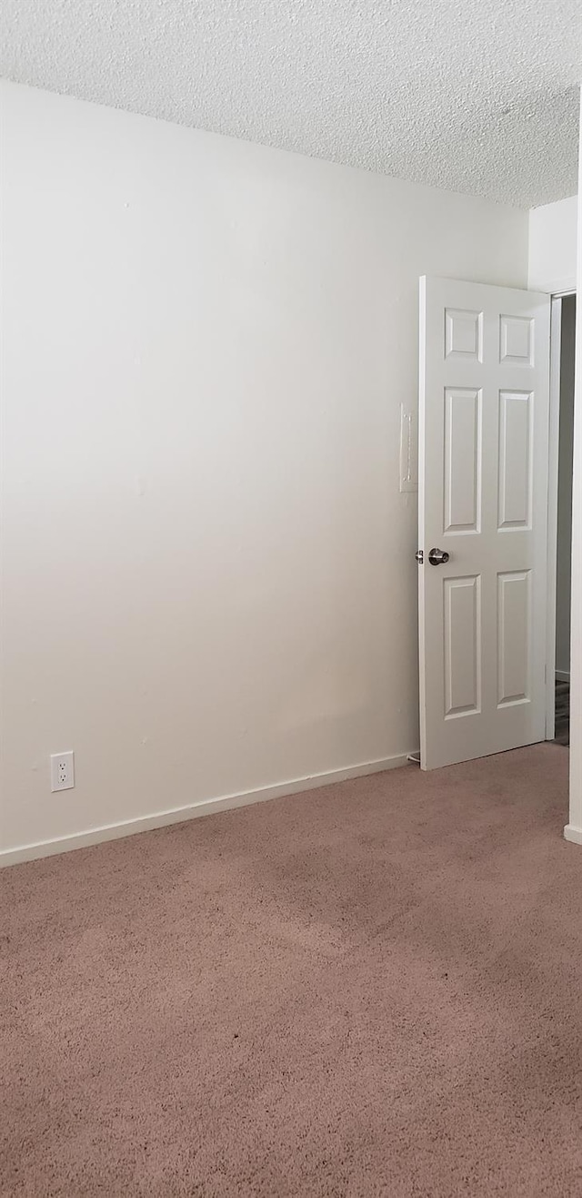 carpeted spare room with a textured ceiling