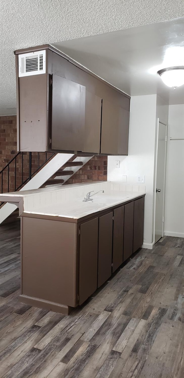 kitchen with a textured ceiling and dark hardwood / wood-style flooring