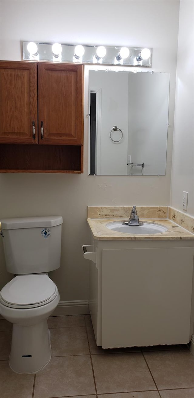 bathroom with toilet, tile patterned floors, and vanity