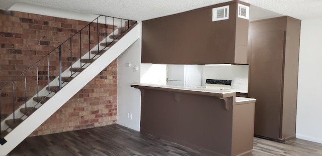 stairs featuring a textured ceiling and hardwood / wood-style floors