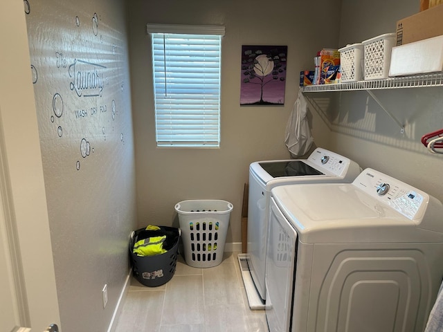 laundry area with light tile patterned flooring and washing machine and clothes dryer