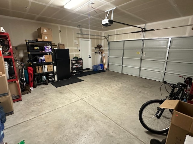 garage featuring a garage door opener and black refrigerator