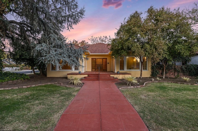 mediterranean / spanish house featuring a lawn