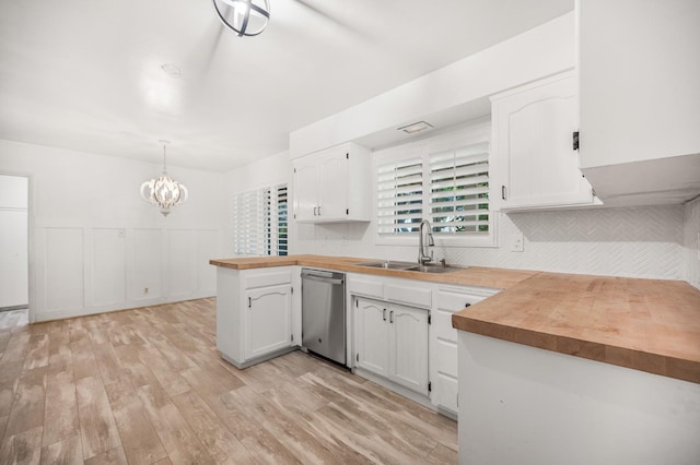 kitchen featuring dishwasher, hanging light fixtures, kitchen peninsula, sink, and white cabinetry