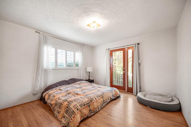 bedroom featuring access to outside, multiple windows, and hardwood / wood-style flooring