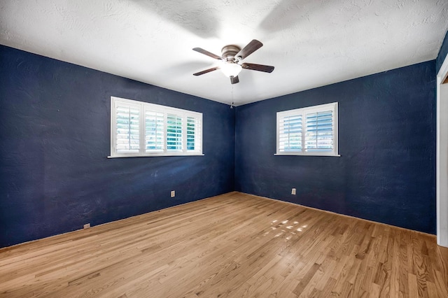 unfurnished room with ceiling fan, a textured ceiling, and hardwood / wood-style flooring