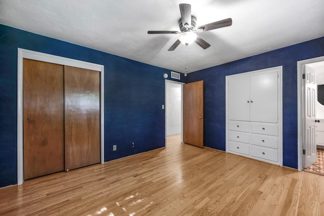 unfurnished bedroom featuring ensuite bath, light wood-type flooring, and ceiling fan