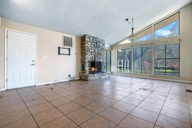 unfurnished living room featuring a fireplace, a textured ceiling, high vaulted ceiling, and light tile patterned floors