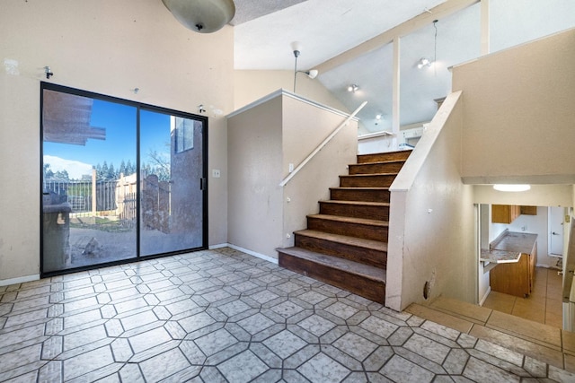 stairway featuring high vaulted ceiling