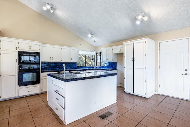 kitchen featuring white cabinets, tile patterned flooring, black appliances, and decorative backsplash