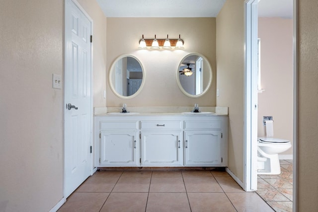 bathroom with toilet, vanity, and tile patterned floors