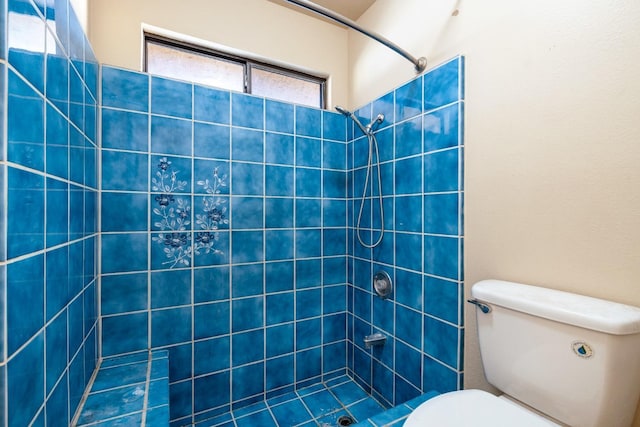 bathroom featuring toilet and tiled shower