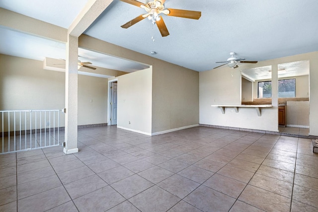 unfurnished living room with light tile patterned flooring and a textured ceiling