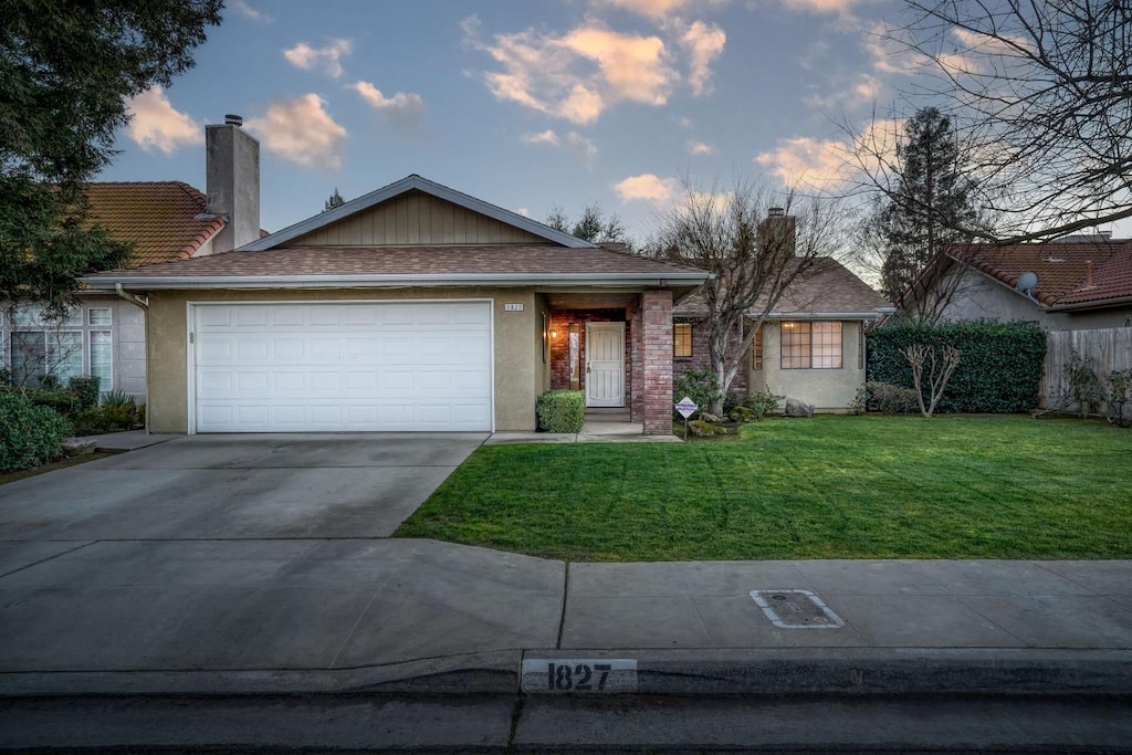 ranch-style home with a lawn and a garage