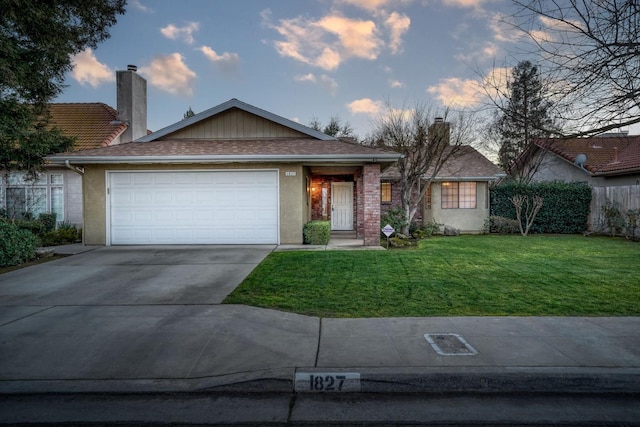 ranch-style home with a lawn and a garage