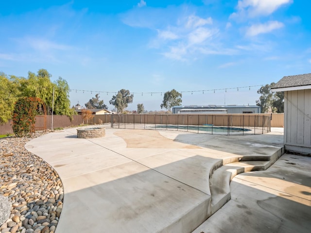 view of patio featuring a fenced in pool, a fenced backyard, and a fire pit