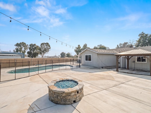 view of patio featuring a fenced in pool, an outdoor fire pit, fence, and a gazebo