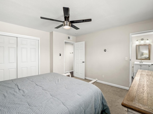 carpeted bedroom with ceiling fan, a sink, visible vents, baseboards, and a closet